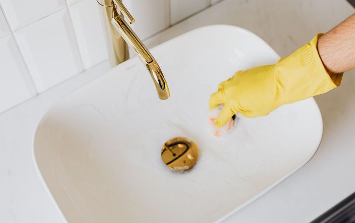 White bathroom sink and gold faucet rinsed clean