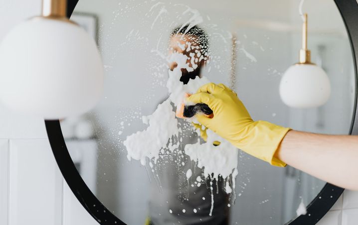 Round bathroom mirror covered in soap before cleaning