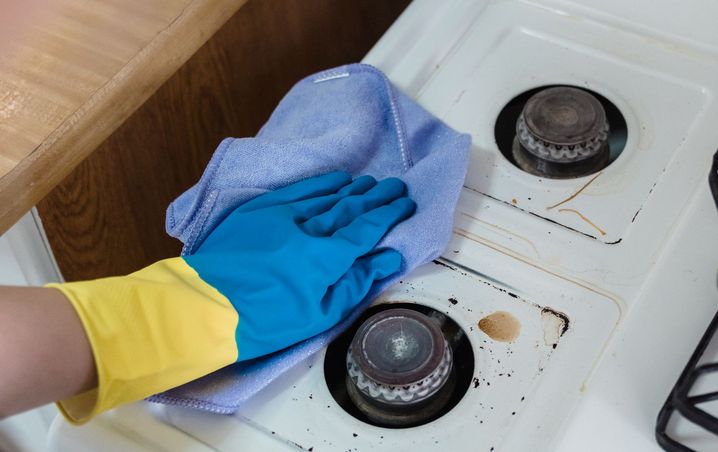White gas stovetop with food spills before cleaning